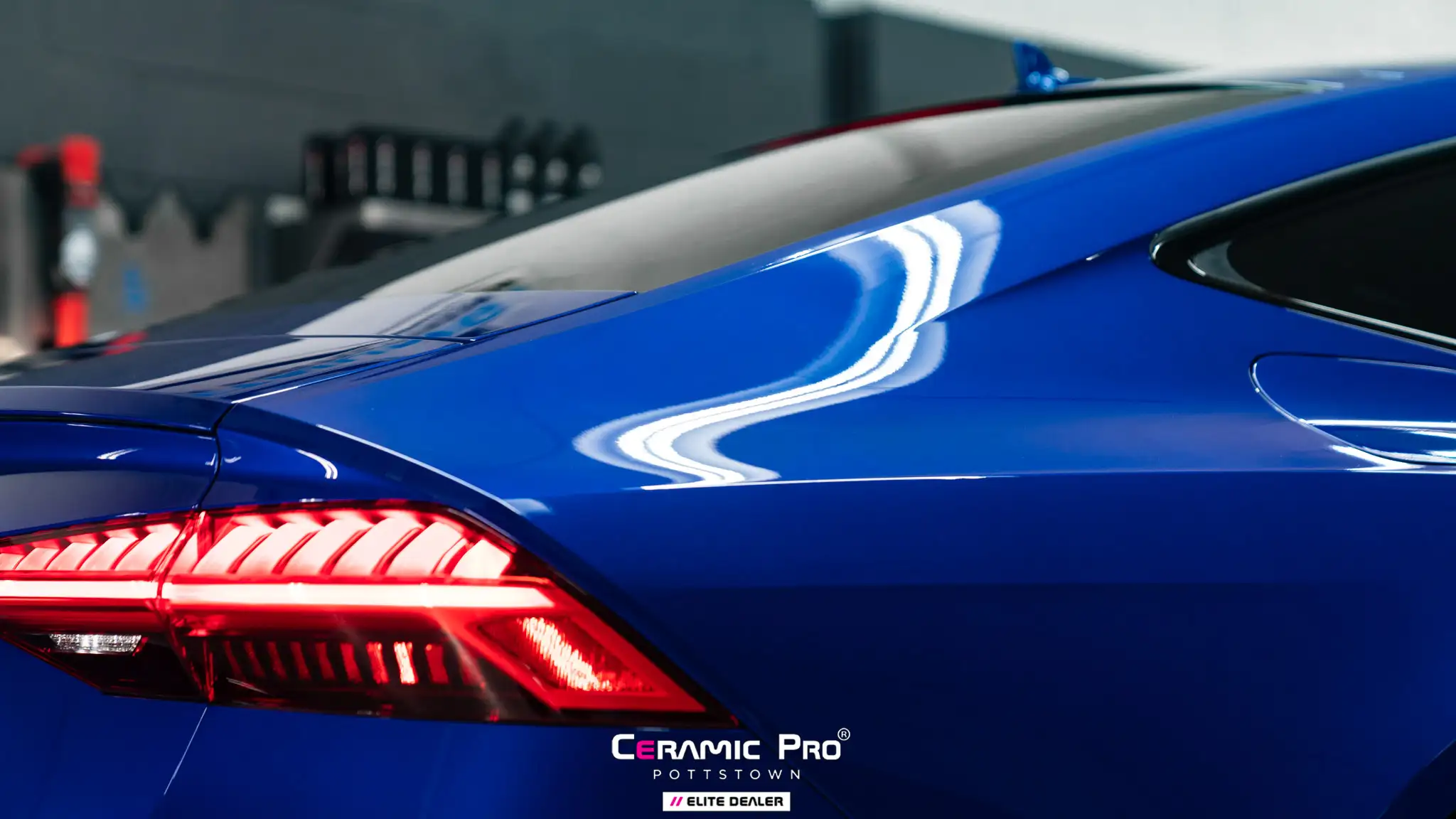 A shiny black car after detailing with reflections on the hood.
