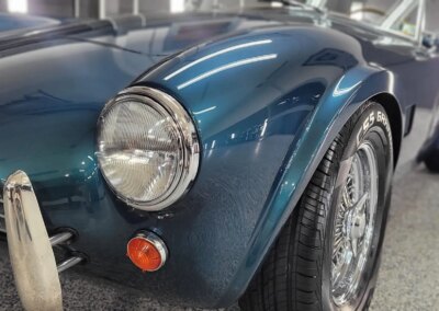 A car undergoing detailing in a well-equipped garage.