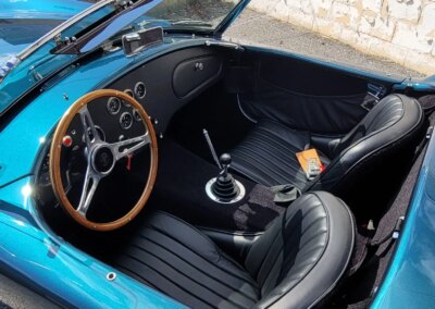 A red sports car undergoing professional detailing in a workshop.