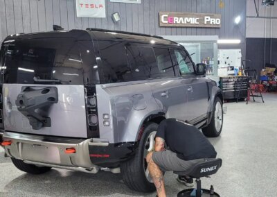 A car with a shiny, polished exterior parked in a detailing workshop.