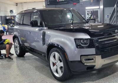 A car undergoing detailing in a well-equipped garage.