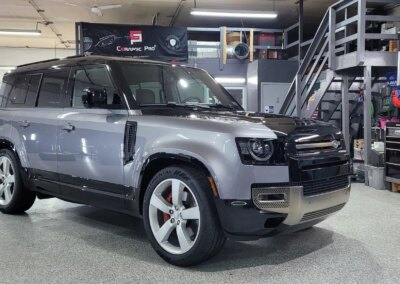A shiny black car after detailing service in a well-lit garage.