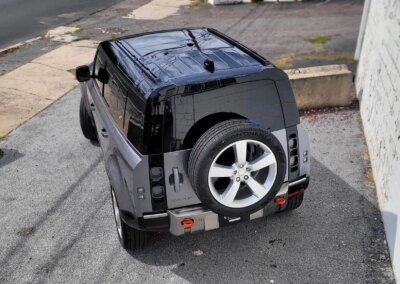 A shiny black car after detailing, parked outside on a sunny day.