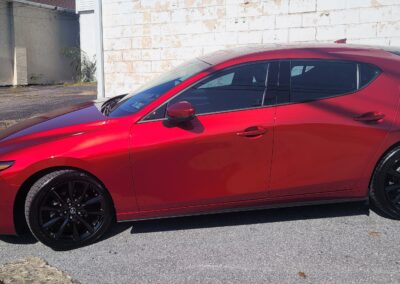 A car detailed with a shiny exterior and clean wheels.