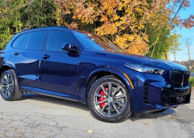 A car with a shiny black exterior after detailing service.