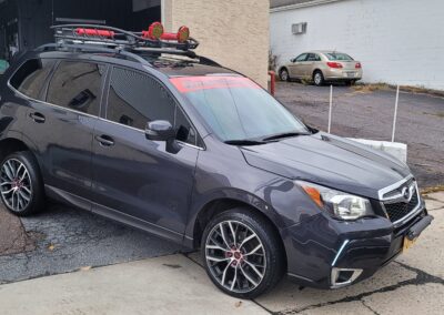A car with open doors undergoing a thorough detailing service.