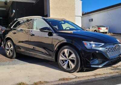 A car with open doors being detailed at Total Detailing Auto Spa.