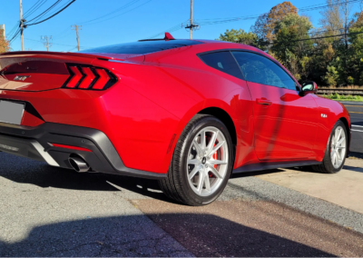 Red Mustang car with glossy ceramic coating finish parked outside.