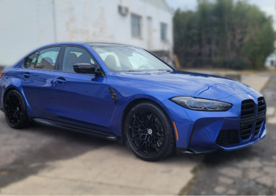 Car being washed with high-pressure water at a detailing service.