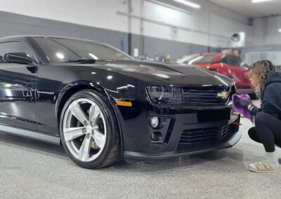 A car with open doors being detailed by a professional at Total Detailing Auto Spa.