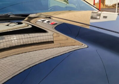 A red car being detailed by a professional at Total Detailing Auto Spa.