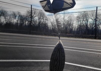 A shiny black car with a reflection, parked outside on a sunny day.